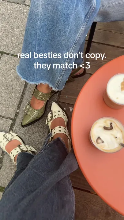 Two pairs of Ganni slingback shoes next to iced coffees on a red table
